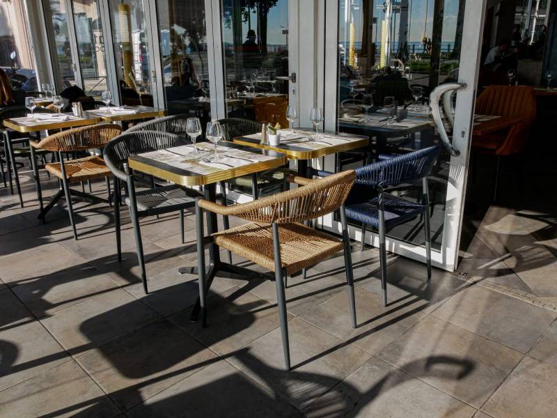 Terrasse moderne avec fauteuil Amsterdam avec plateaux en cerclage doré en aluminium à Nice