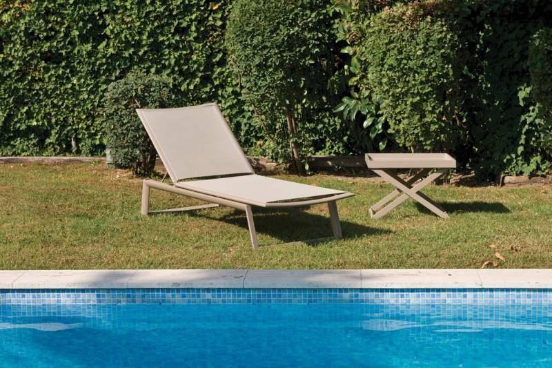 Transat de la collection themis en toile twhitchell taupe dans un jardin à Biarritz