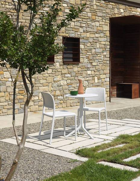 chaise de la collection Bora couleur blanc autour d'une table en extérieur à Paris